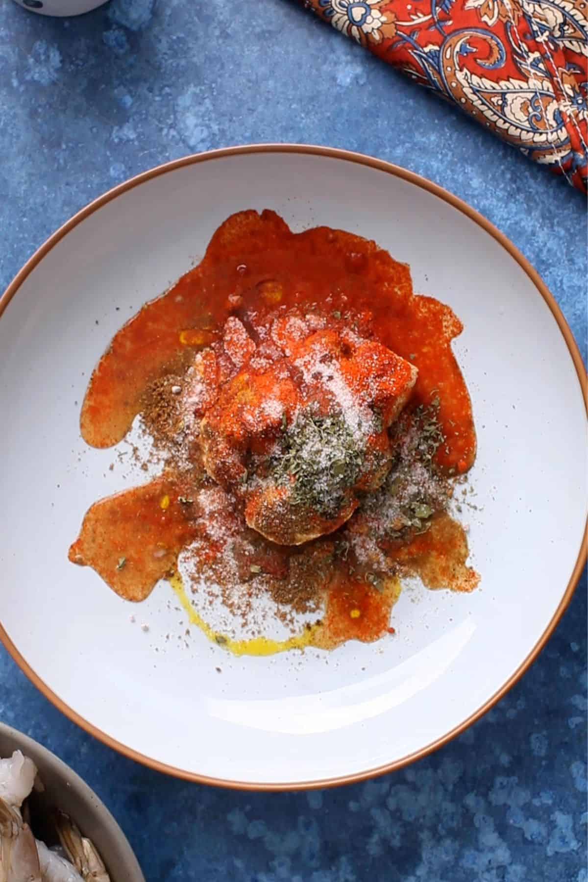 Tandoori ingredints added to a large light blue bowl. 