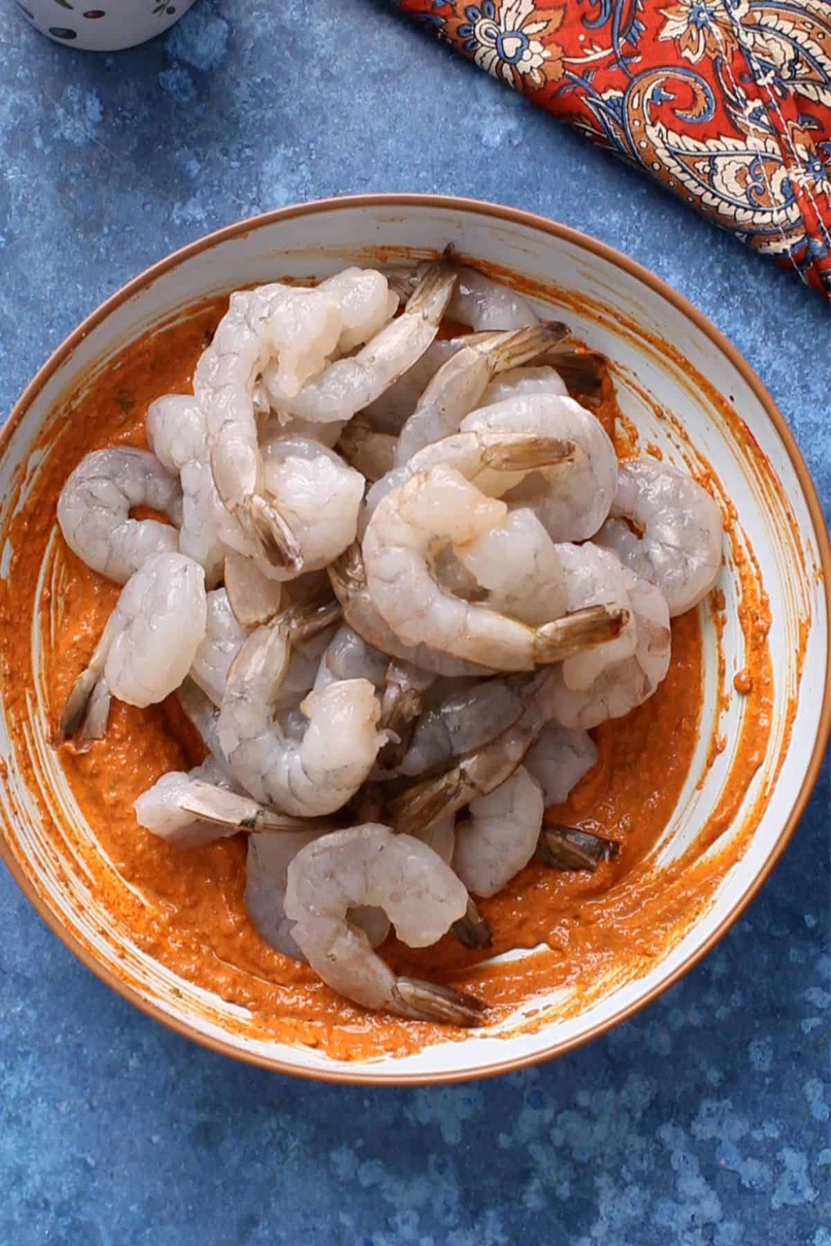 Raw shrimp is added over the marinade.