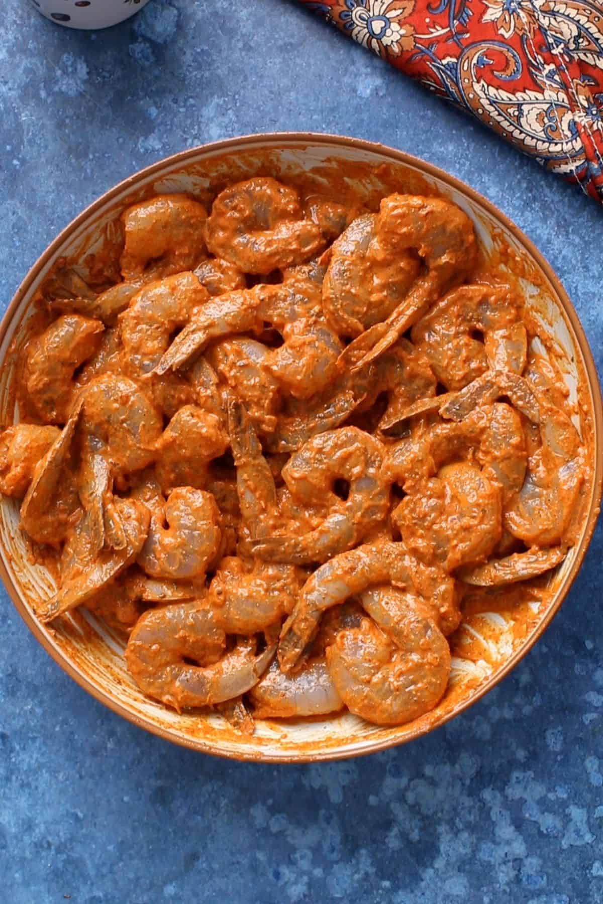 Tandoori prawns are coated in marinade.