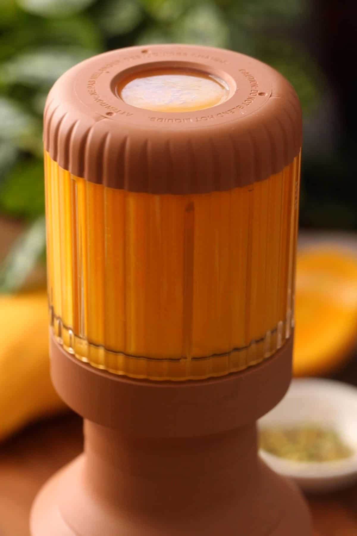 Blending mango in a brown color jar.