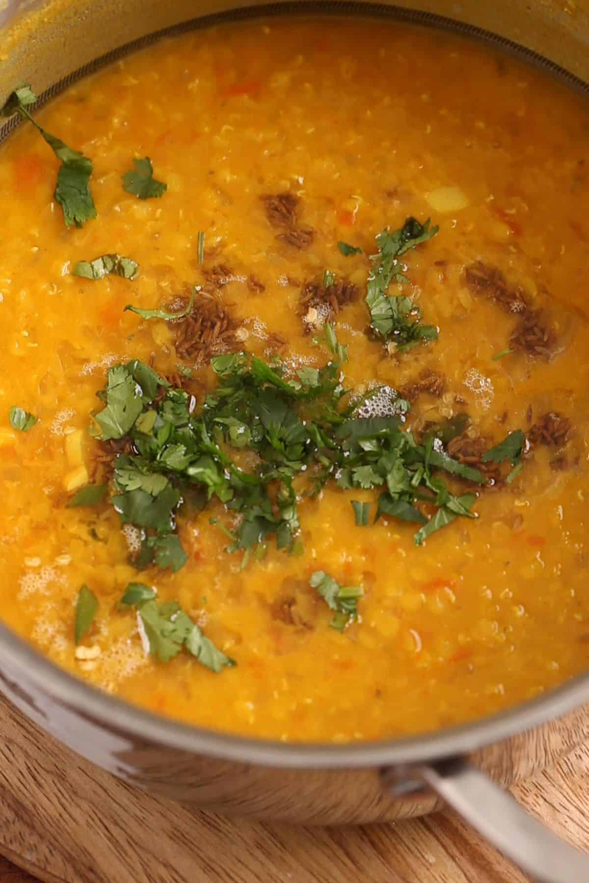 Tadka and chopped cilantro is added to the cooked masur dal. 