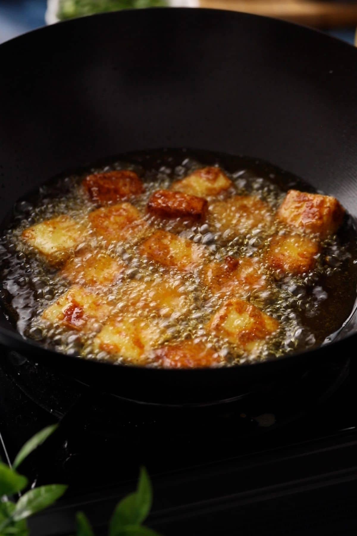 Deep frying paneer in a wok. 