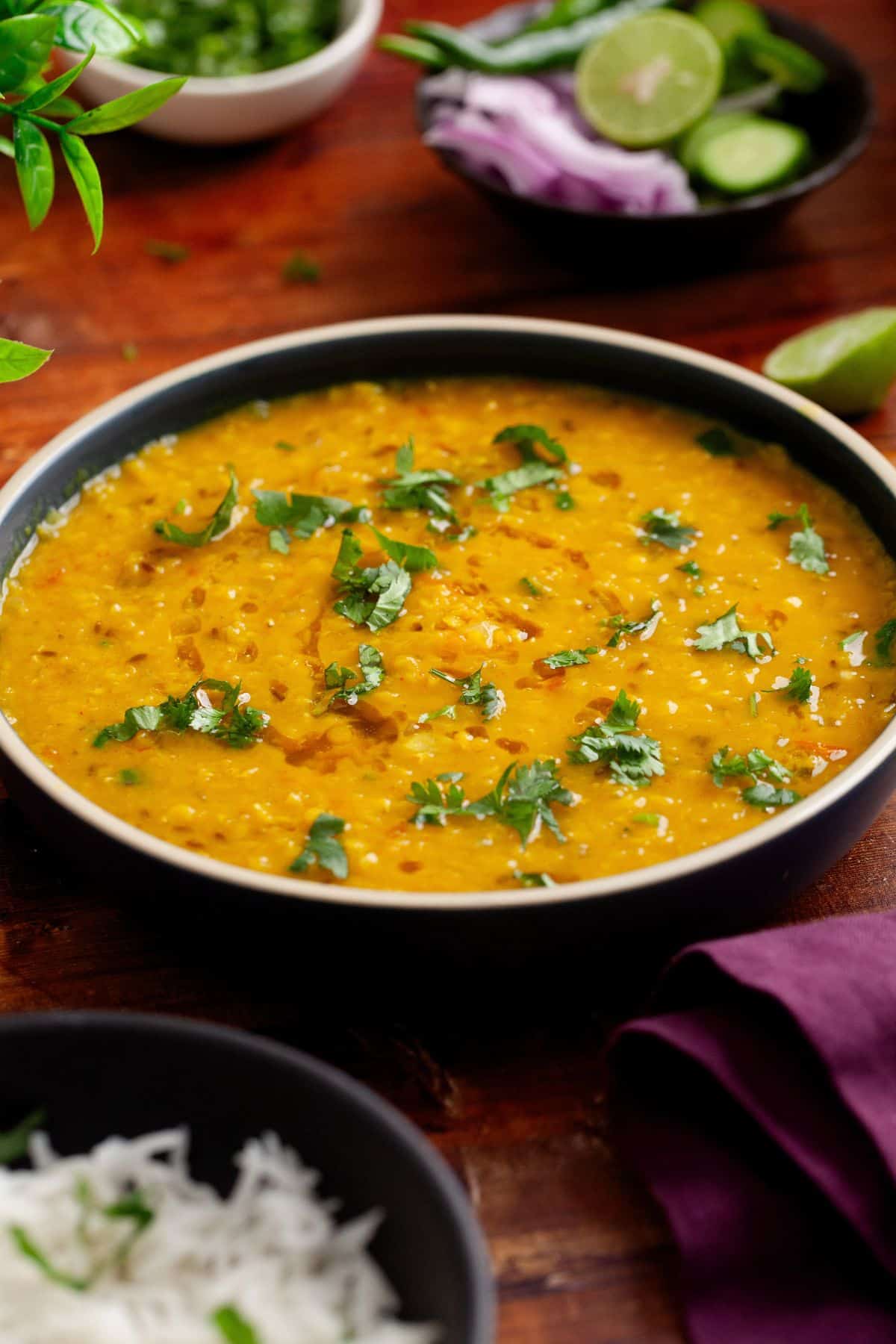 Side view of masoor dal served with drizzle of ghee and garnish of cilantro.