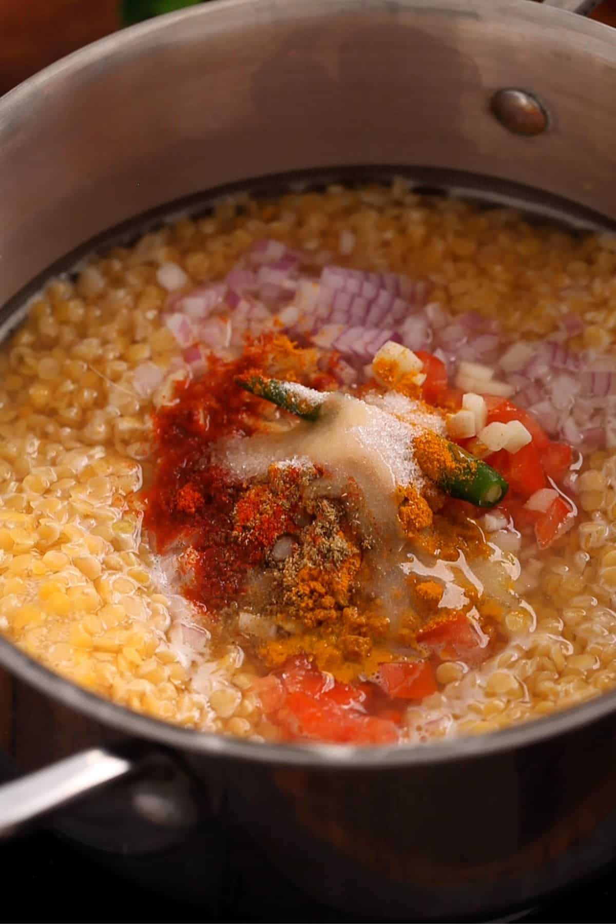 Aromatics, spices and ghee is added to dal. 