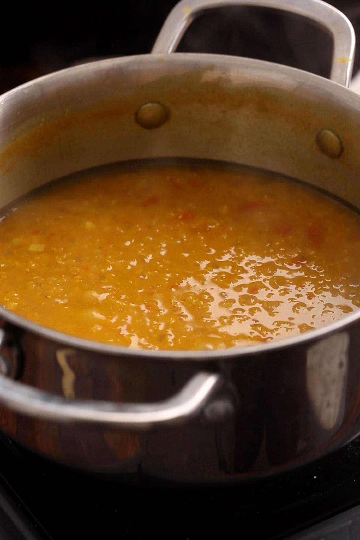 Cooked masoor dal is looking creamy after mashing it with spoon.