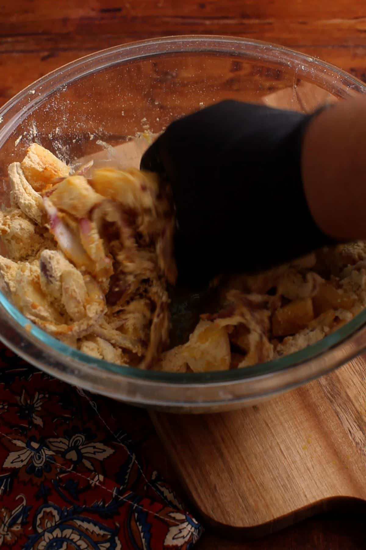 Pakora ingredients are mixed and squished by hand to bring together.