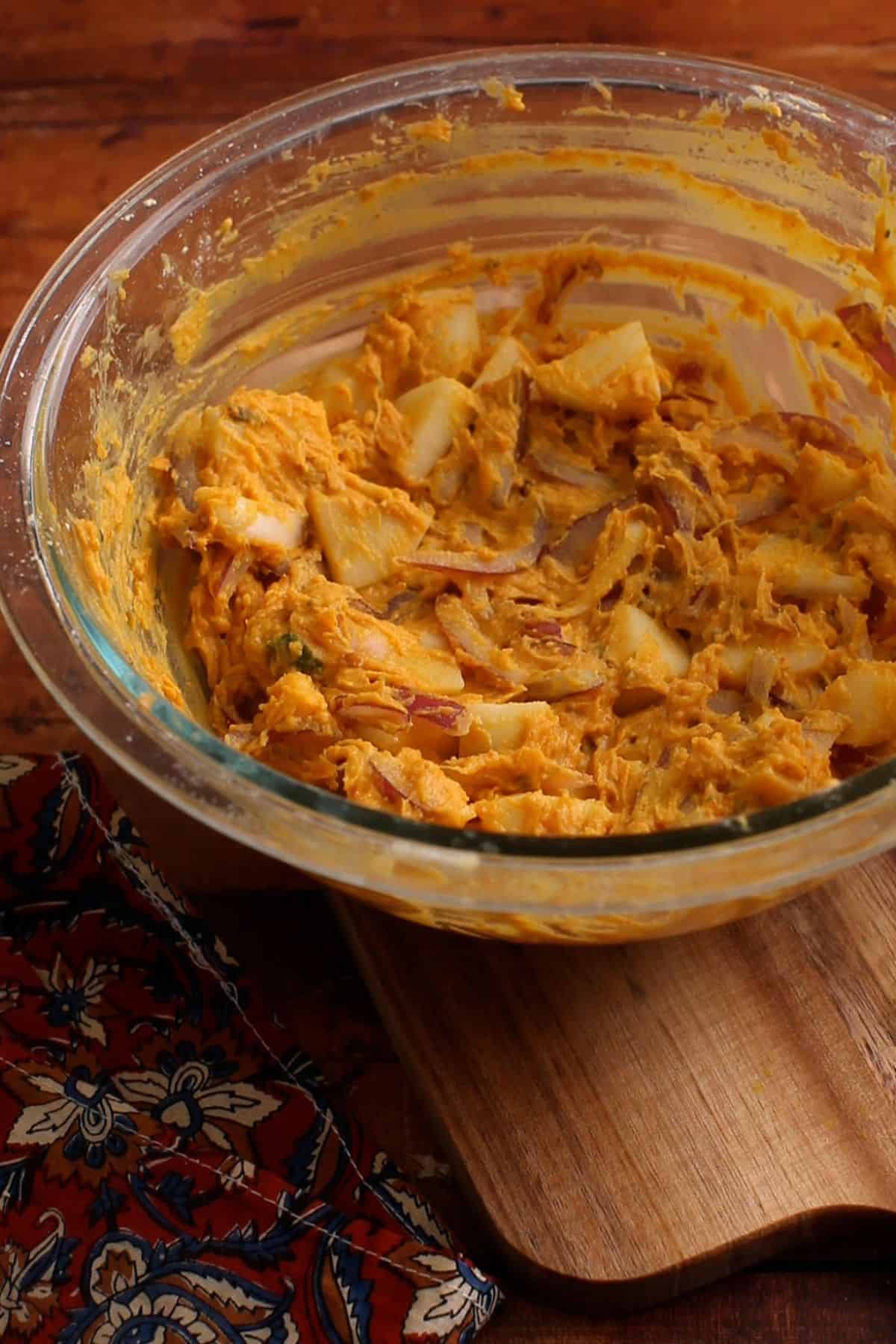 A thick pakora mixture is ready for deep frying.