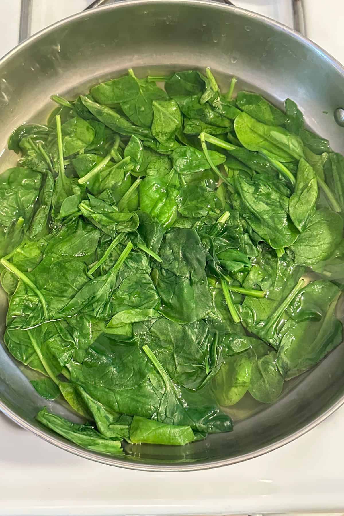 Blanching spinach in stainless steel indian kadai.