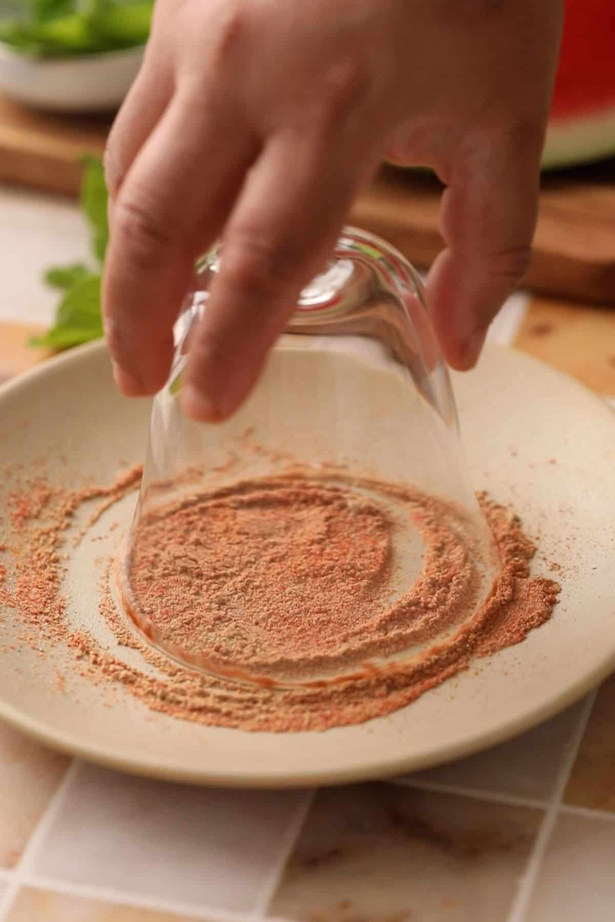 Coating the rim of serving glasses with spices. 