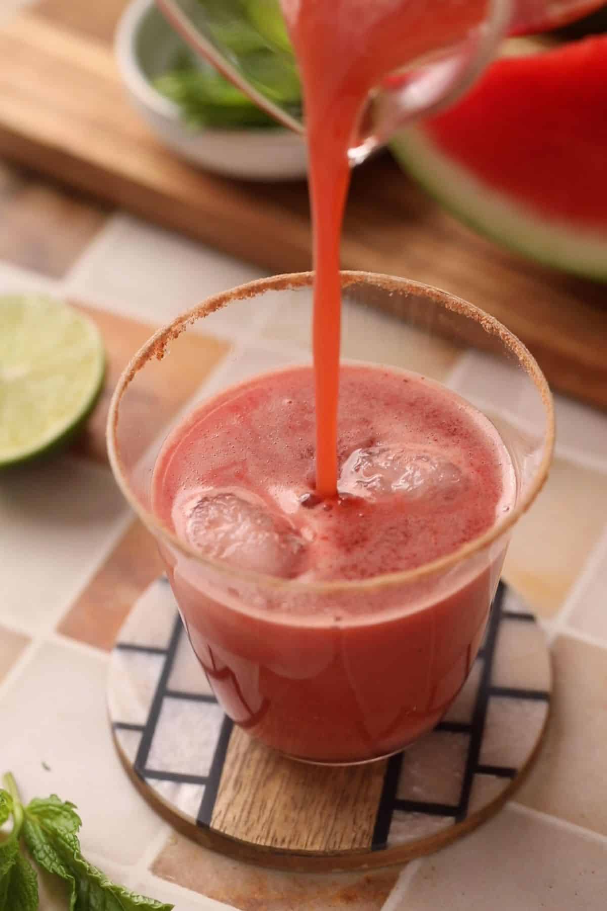 Jaljeera is being poured into the serving glass. 