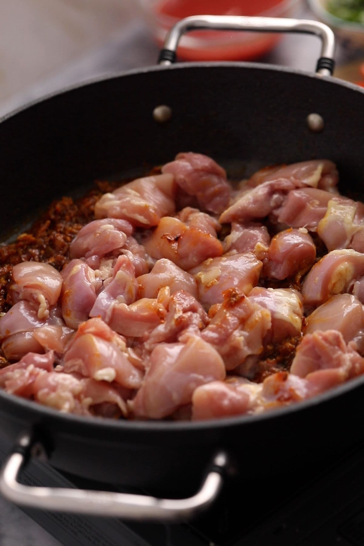 Chicken pieces are added to the jalfrezi masala. 