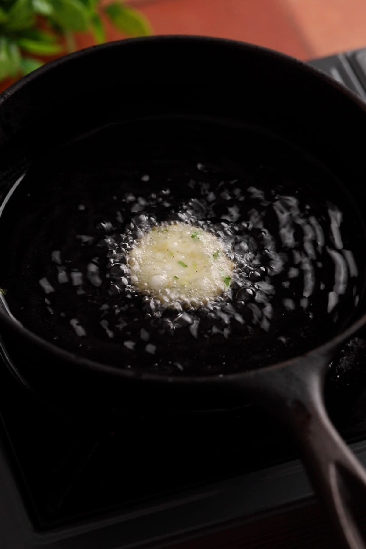 Testing a small portion of sabudana dough mixture for oil temperature and dough consistency.