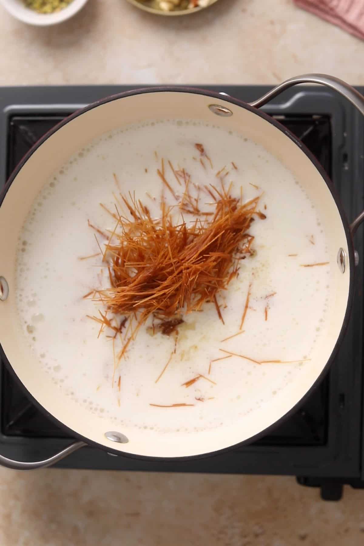 Toasted seviyan are added to simmering milk.