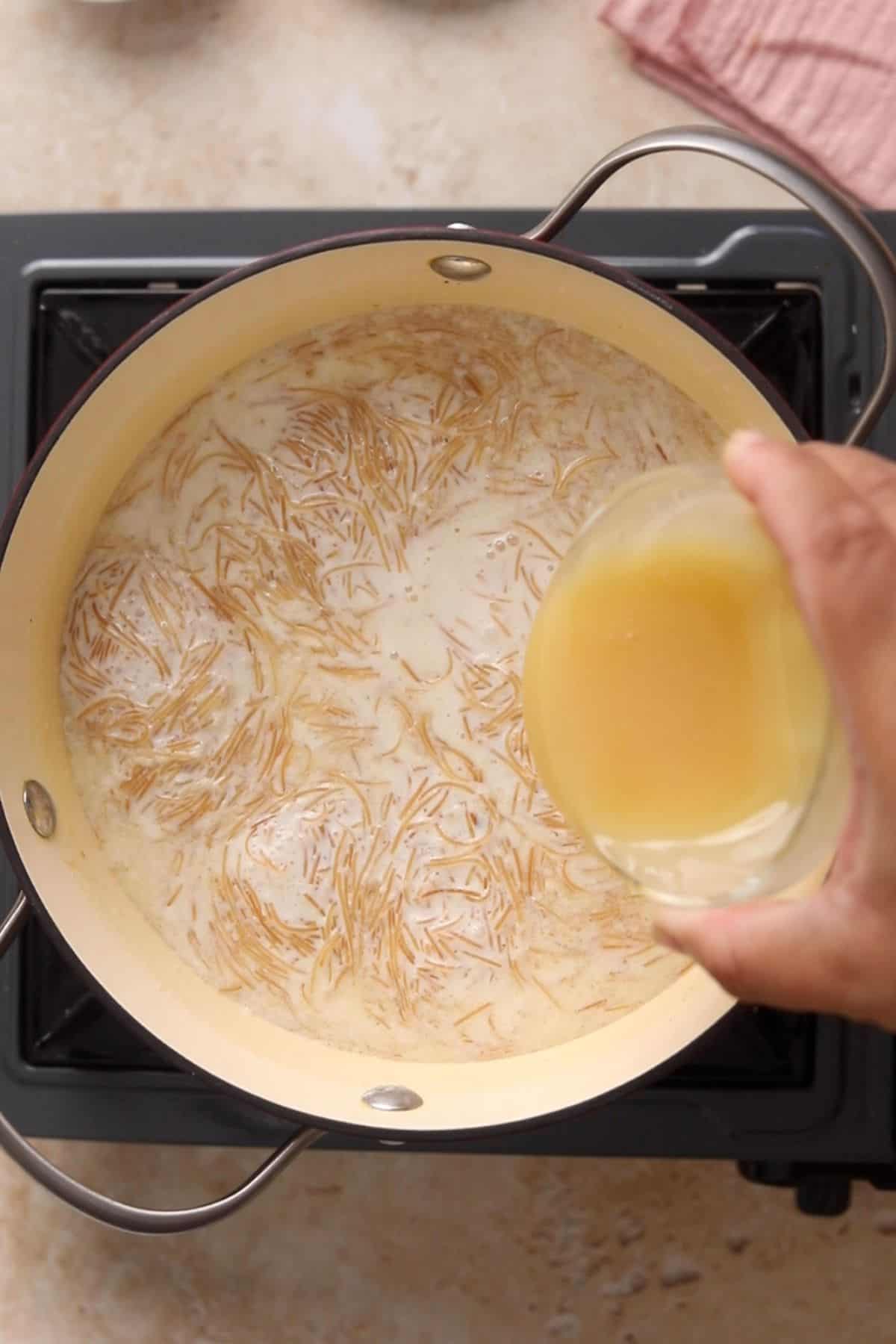 Condensed milk is being added to the seviyan kheer.