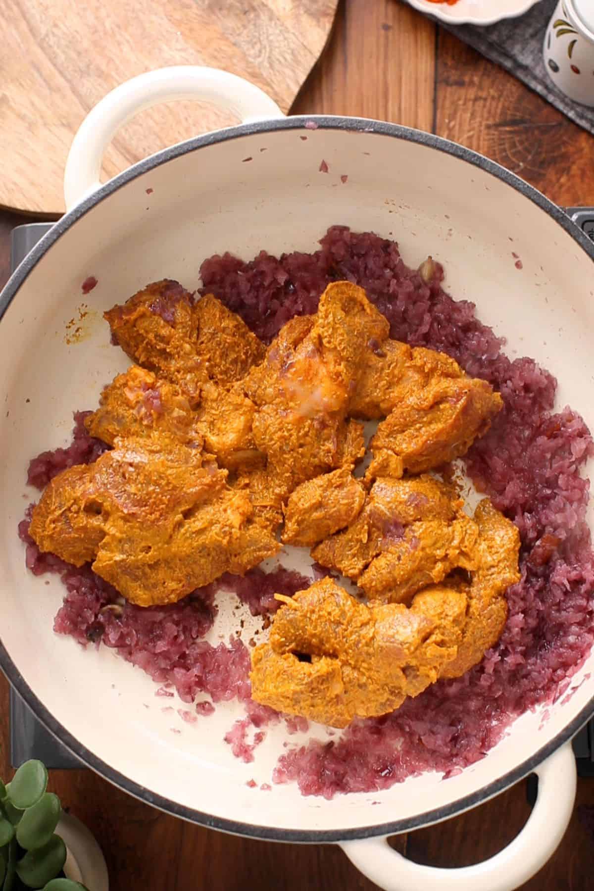 Marinated lamb is added to the soft onions.