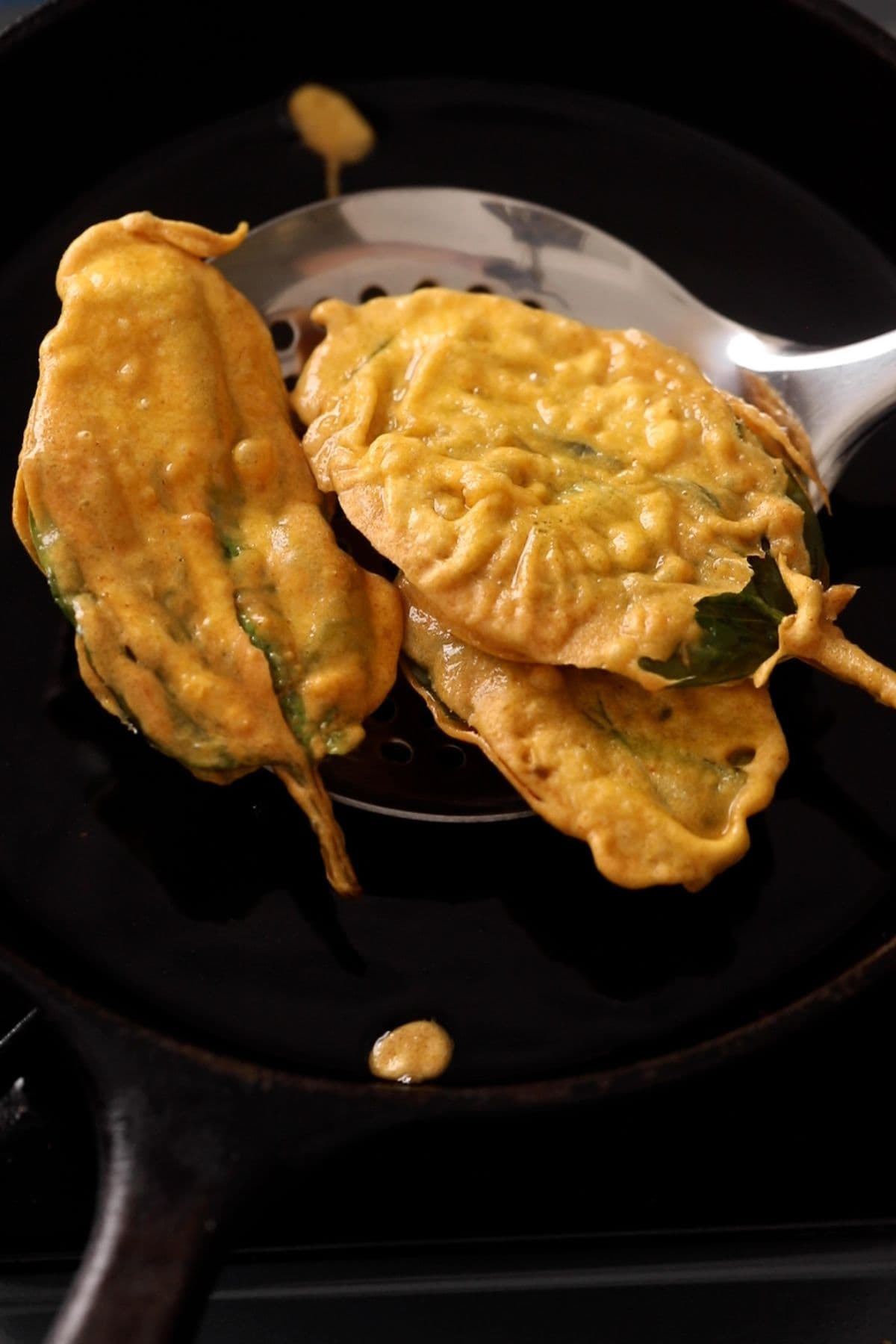 Spinach leaves are golden and crispy and picked using a slotted spoon.