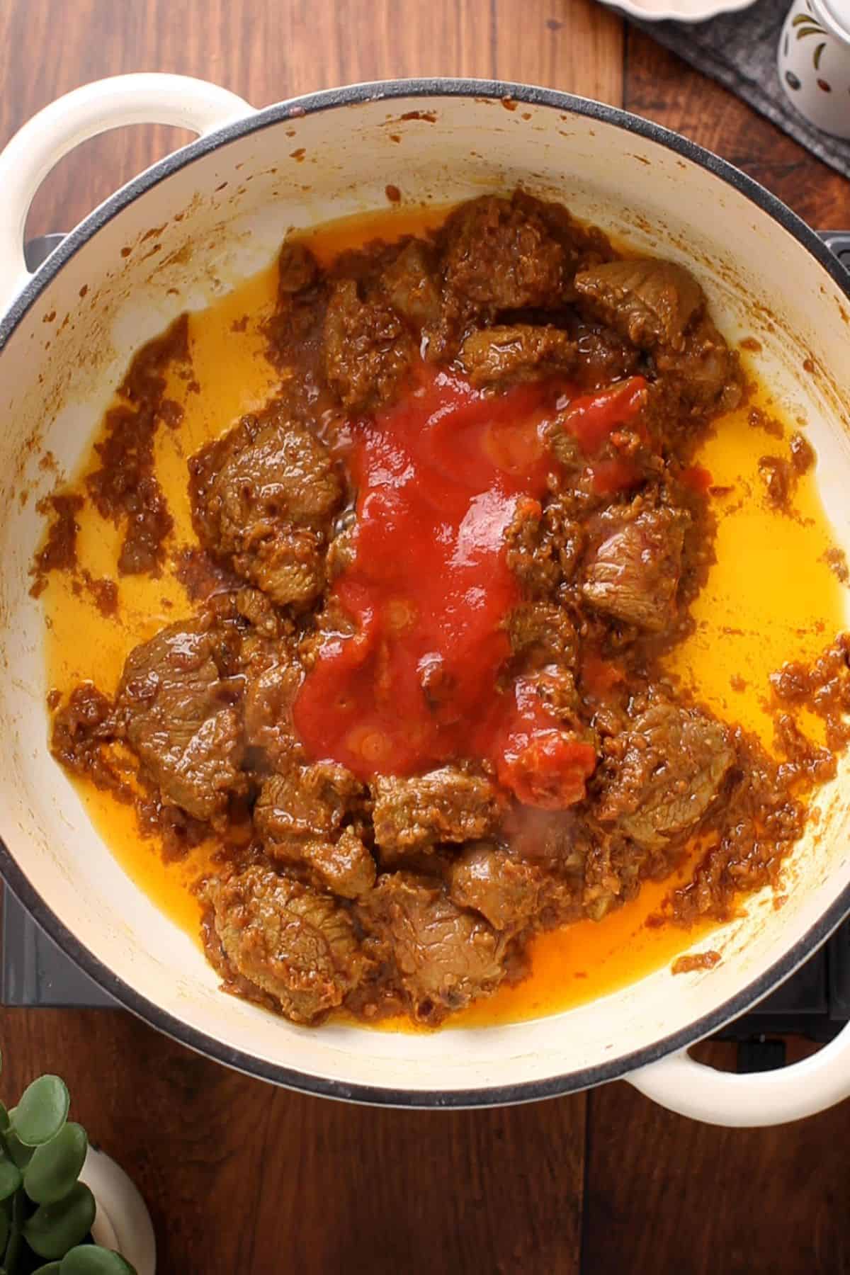 Tomato sauce is added to lamb.