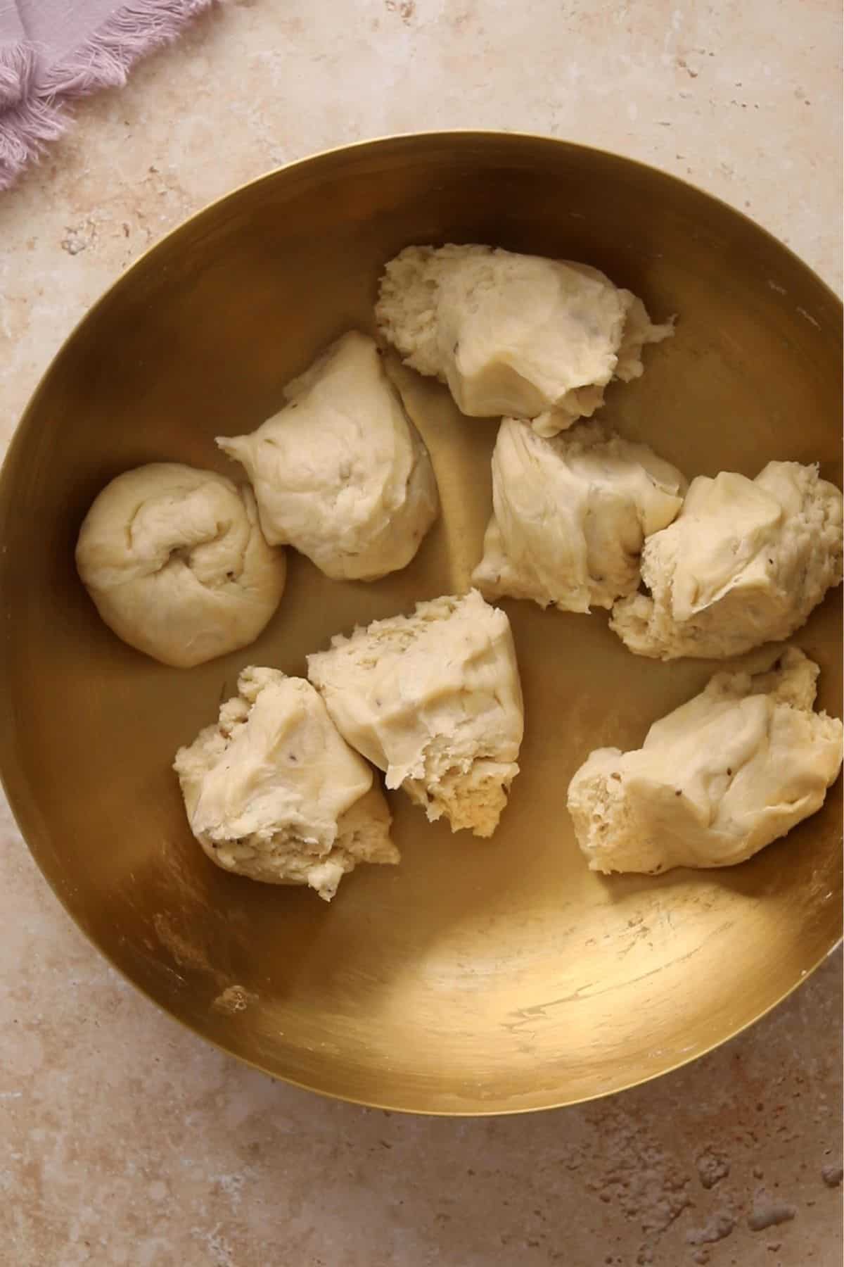 Weighed samosa dough portions in a gold bowl. 