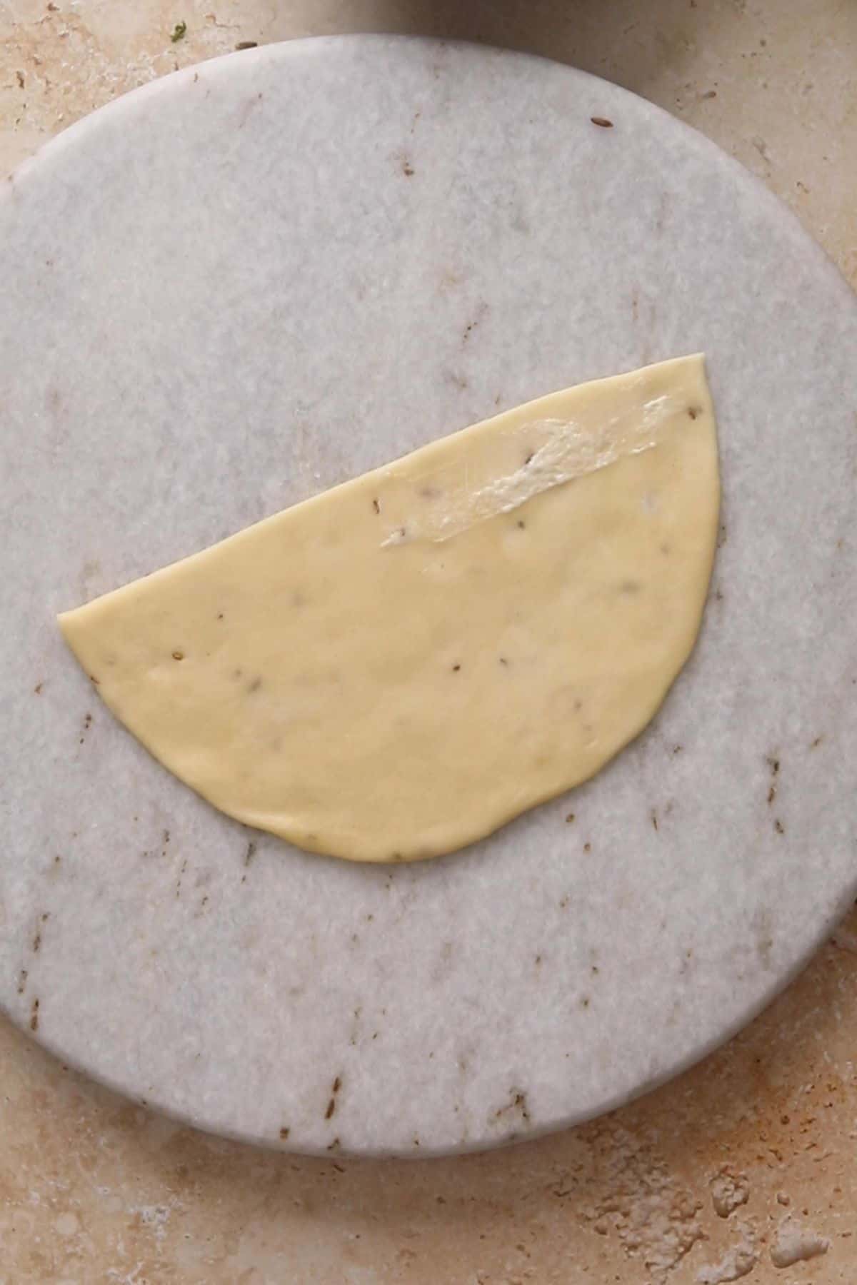 Flour slurry is spread on the straight edge of one semi circle. 