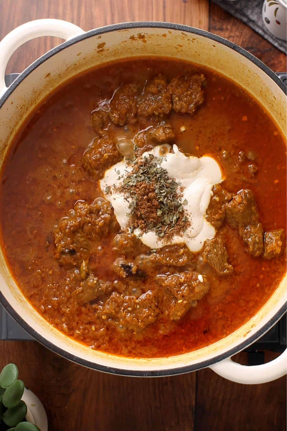 Cashew paste, cream and spices are added to the cooked lamb.