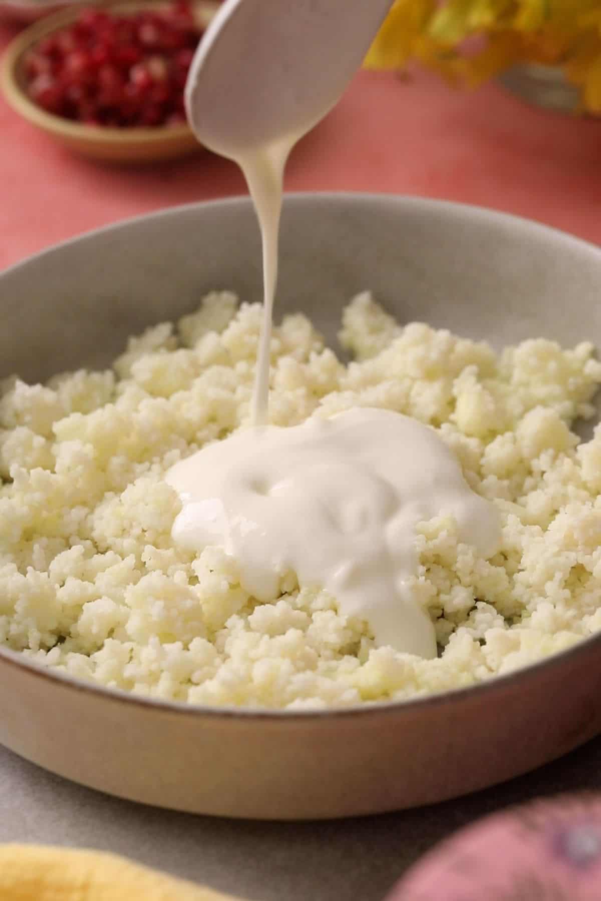 Yogurt is poured over cooked samo rice.