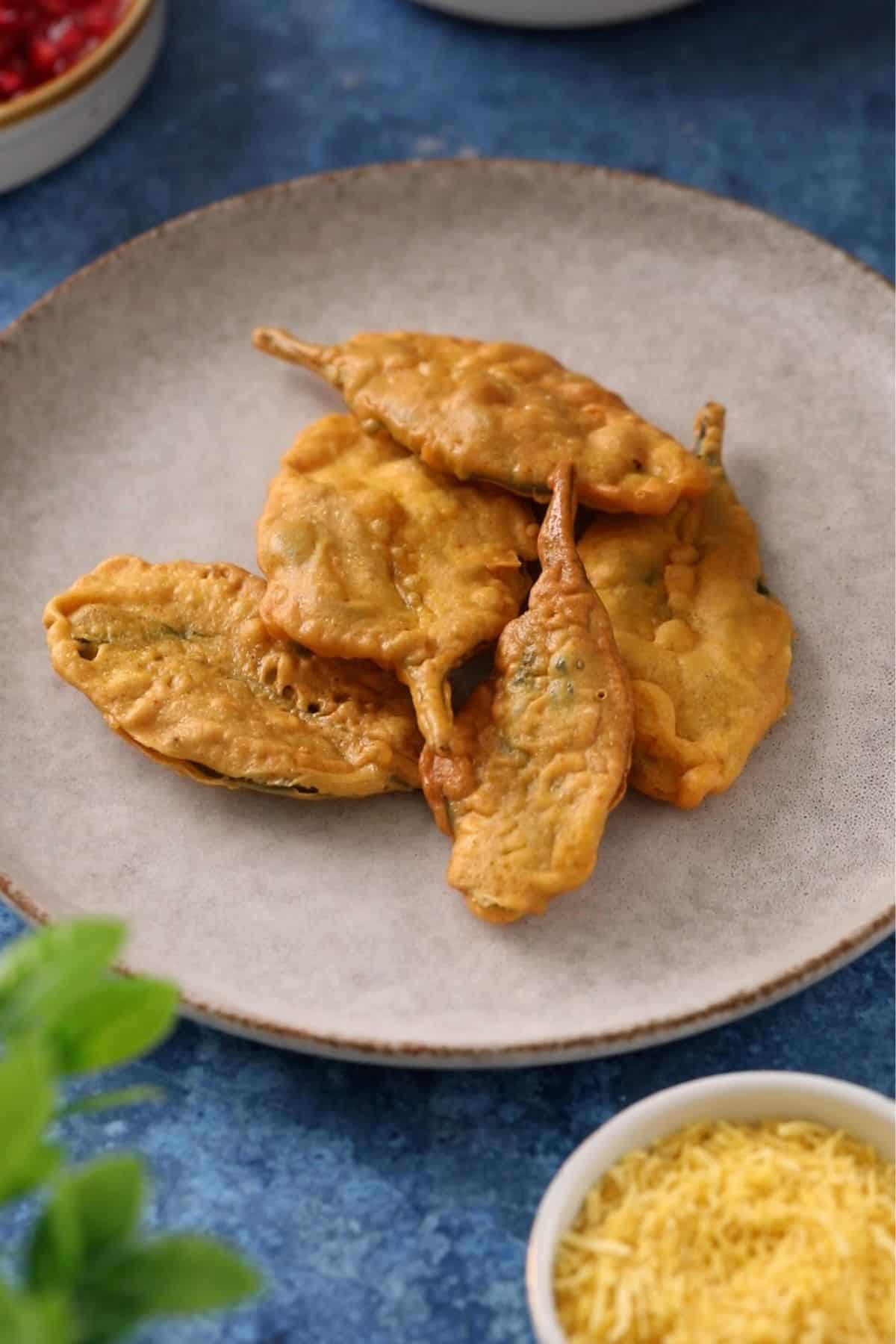 Fried palak patta are placed on a stone plate.