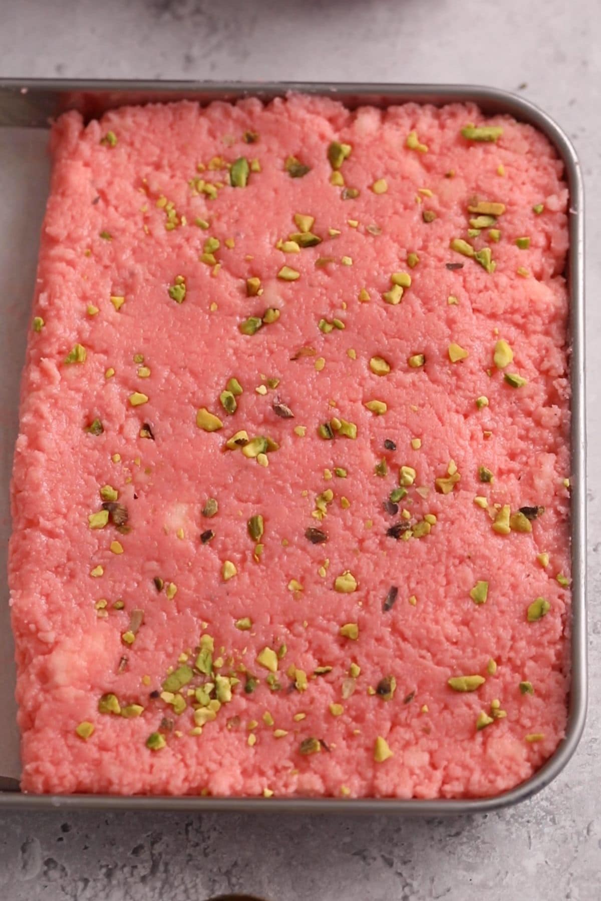 Kalakand mixture is set in a tray.
