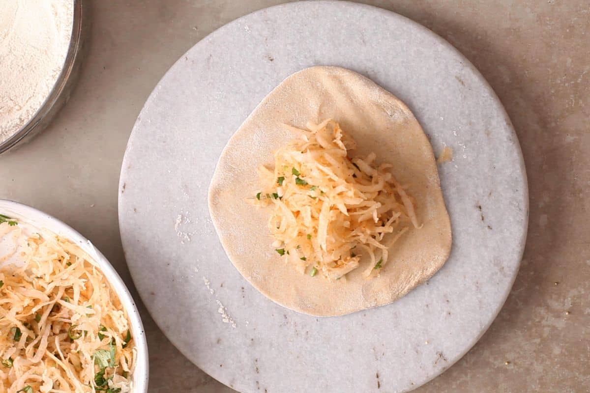 Mooli stuffing is placed on the rolled dough.