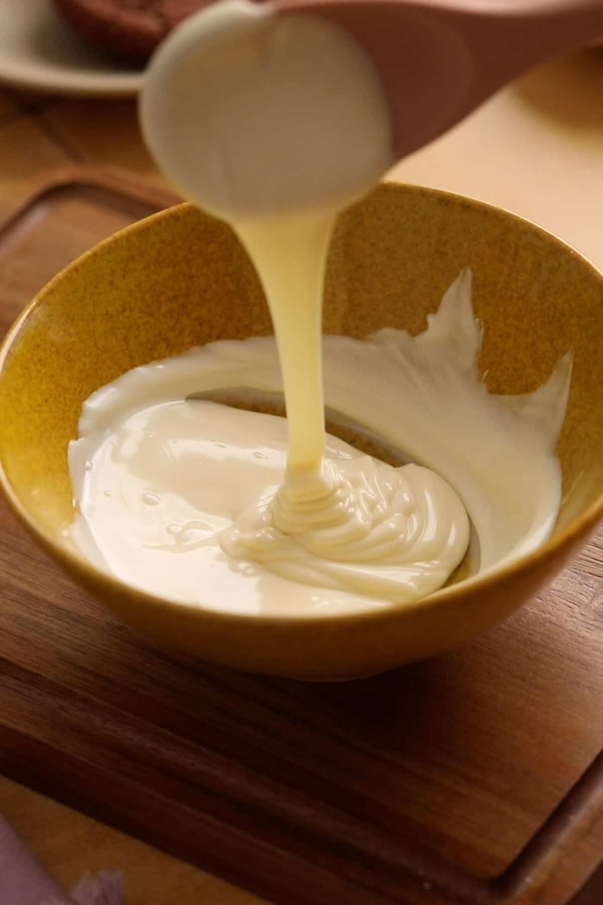 Melted milk chocolate in a yellow bowl. 