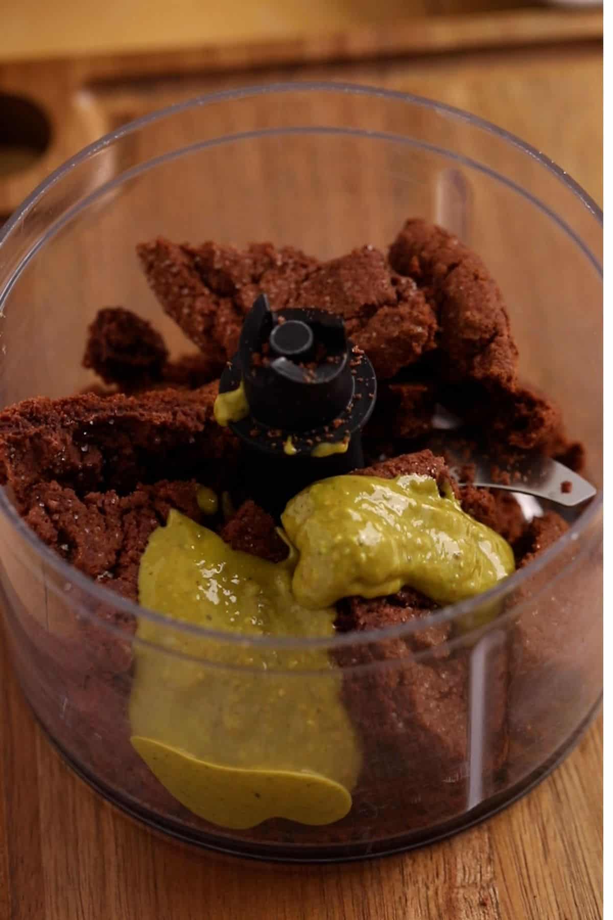 Chocolate cookies and pistachio cream in a small food processor.