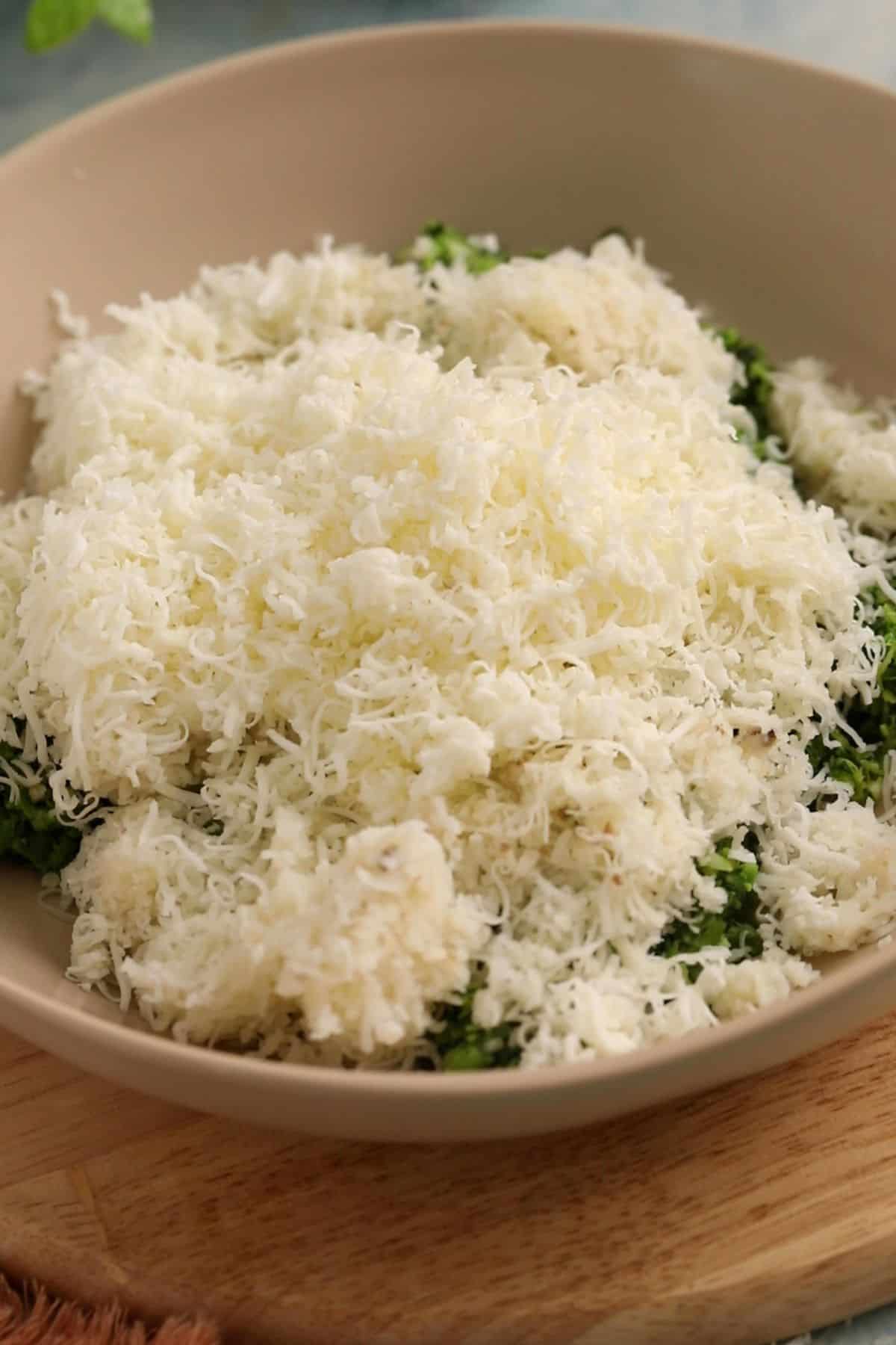 Grated potato and paneer is added to the green vegetables.