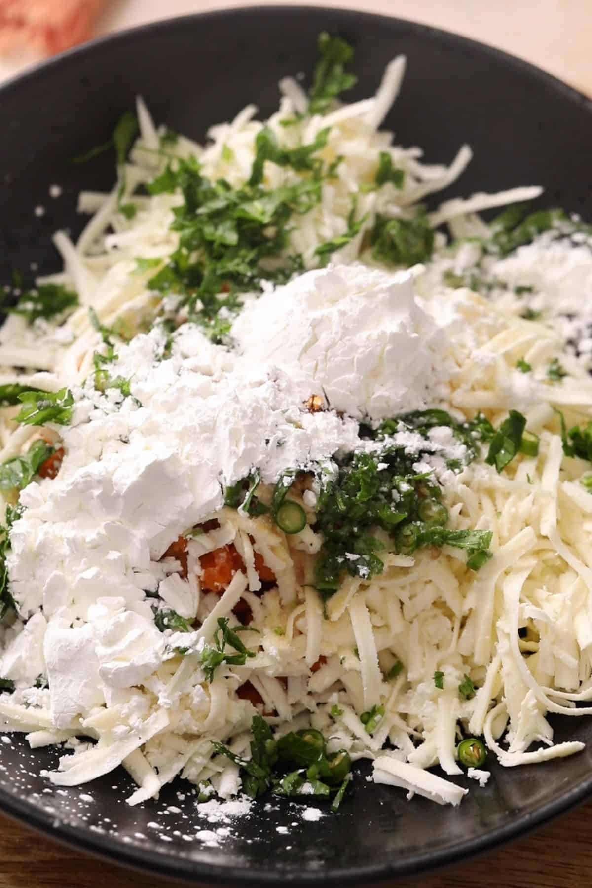 All ingredients for making sweet potato balls are placed in a shallow black bowl. 