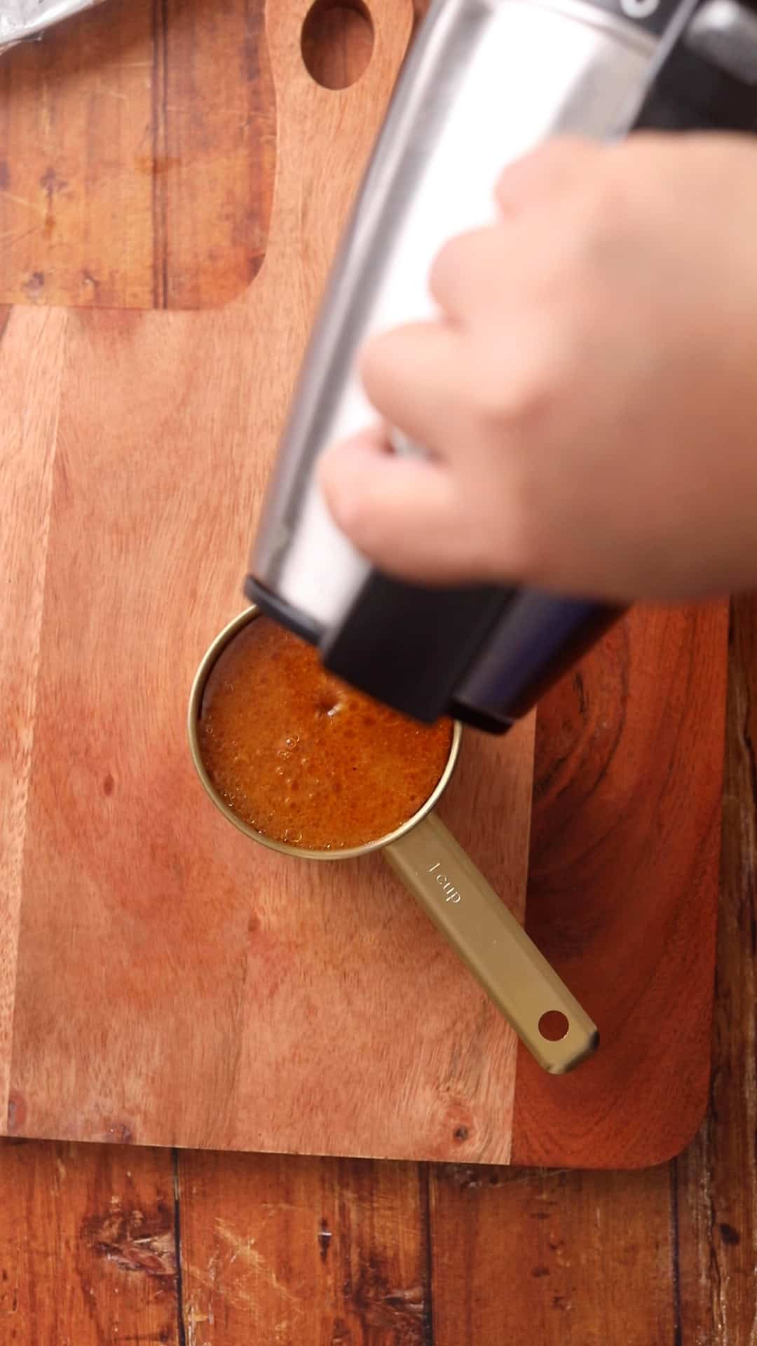 Topping the broth with hot water from a kettle.